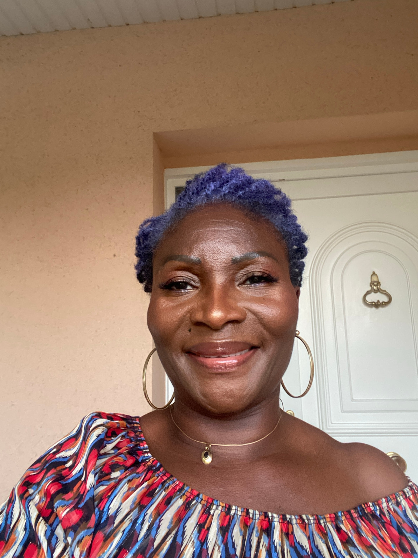 Portrait souriant d’Edwige CBK en imprimé rouge, bleu et blanc